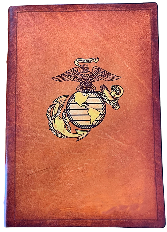 A custom leather bible with an engraved and hand-painted miltary emblem of an eagle on top of a globe. 